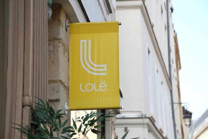 Visit Paris on a running tour with operator Lolë. The yellow Lolë sign outside their headquarters.