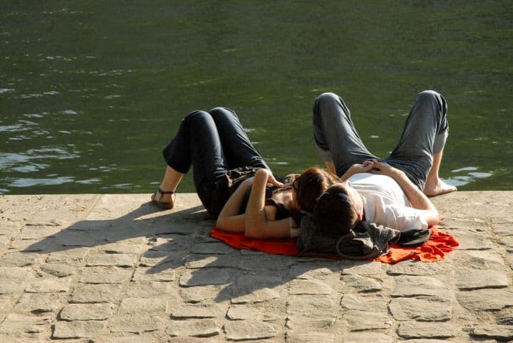 Online Dating in Paris is great because you then get to hang out by the river in summer, like this couple sharing a picnic blanket.
