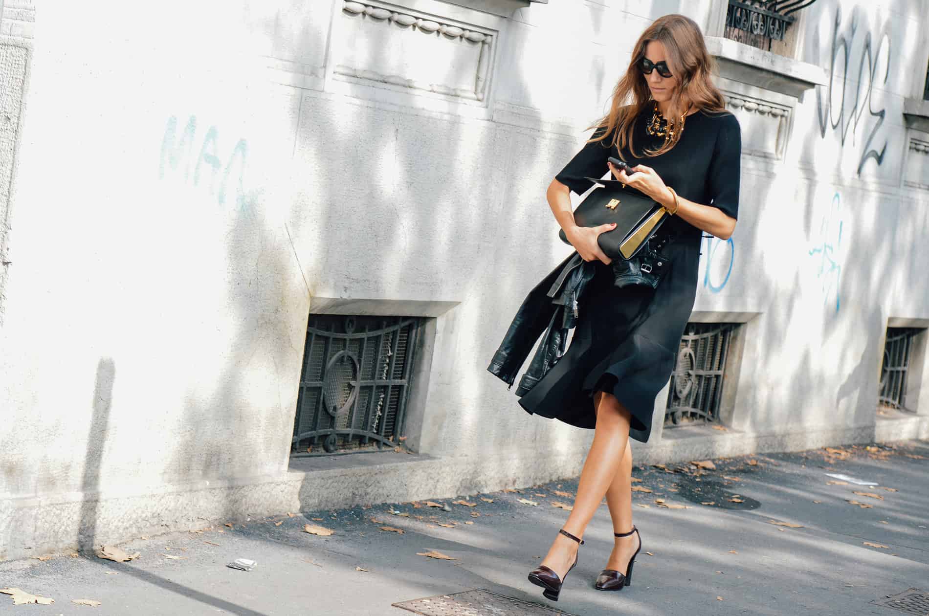 French Chic is all about decoding the Secrets of Paris Fashion, like this Parisian woman who's teamed a well-cut skirt and top with a sleek square handbag and gold statement necklace.