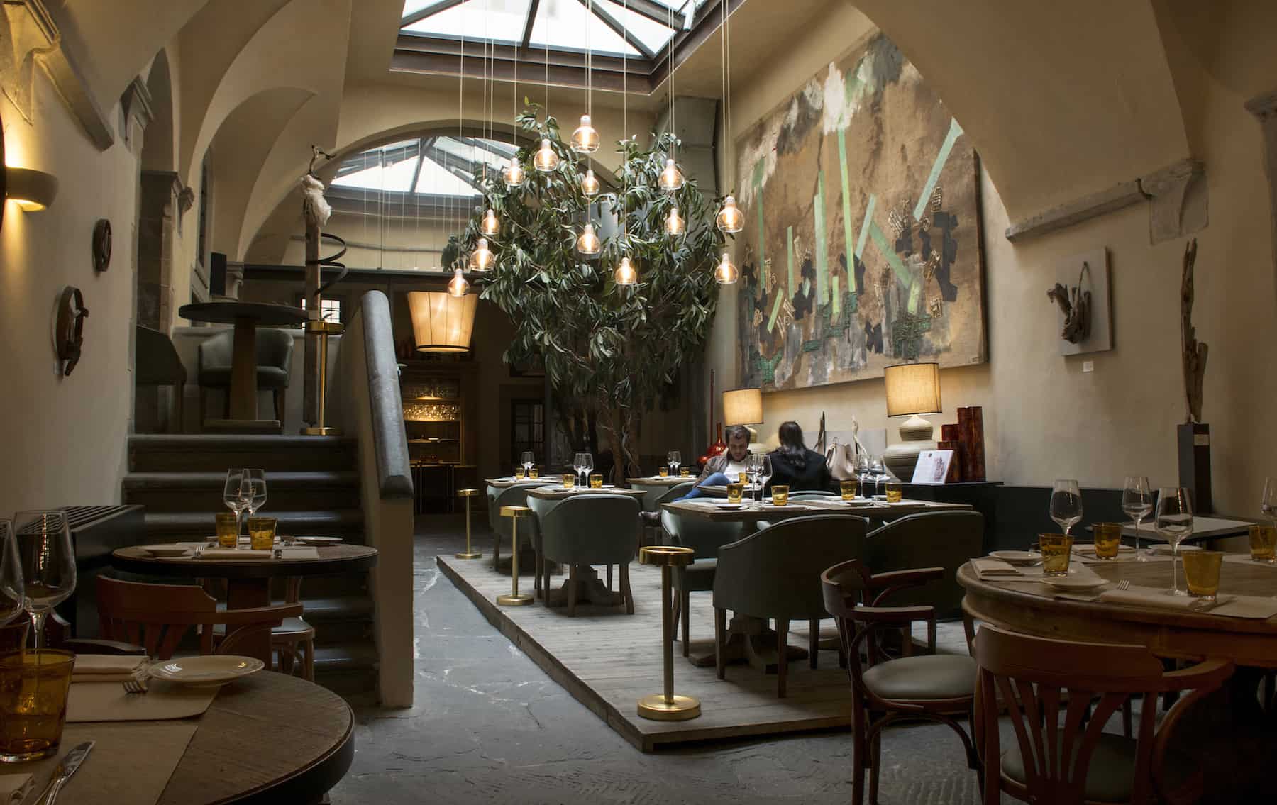 Inside Florence's beautiful Konnubio restaurant with its glass ceiling and and artworks.