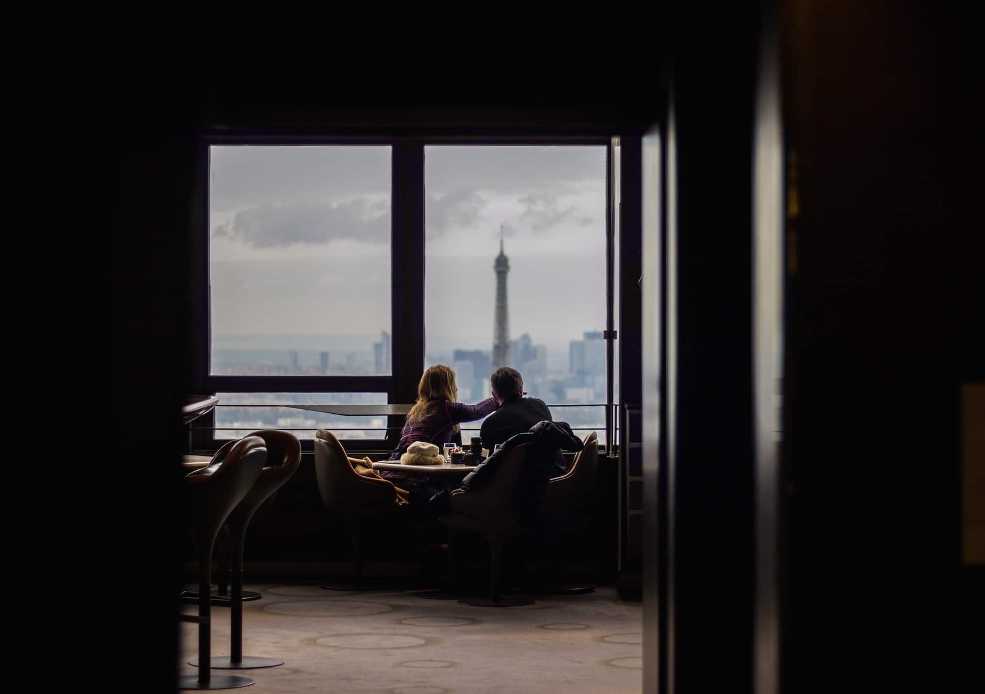 Learning French is easier when you have a French friends you can practise with, like this woman and man having coffee at a café overlooking the Eiffel Tower.