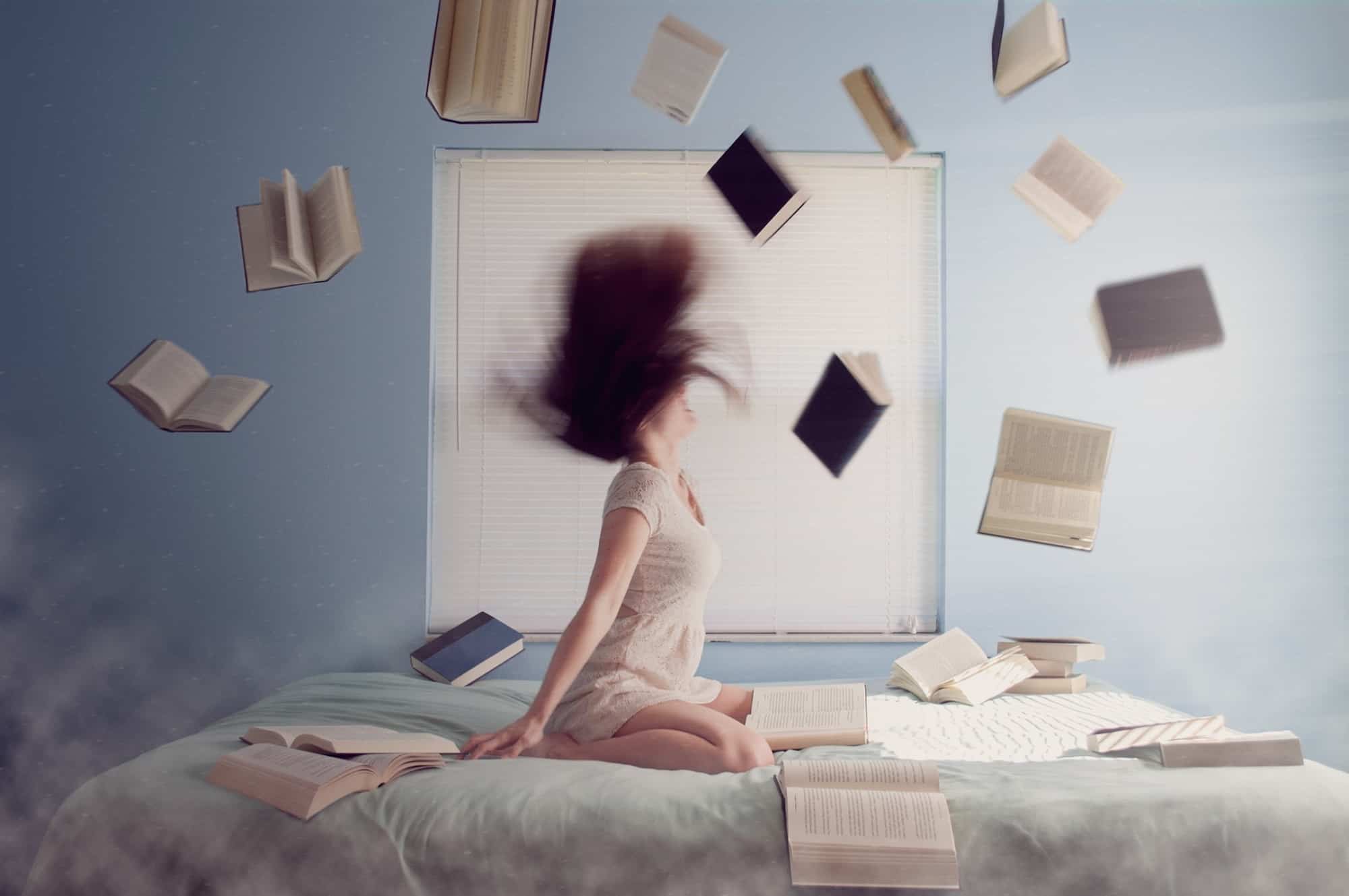Learning French can get frustrating but don't give up, like this girl sat on her bed, throwing books up in the air.