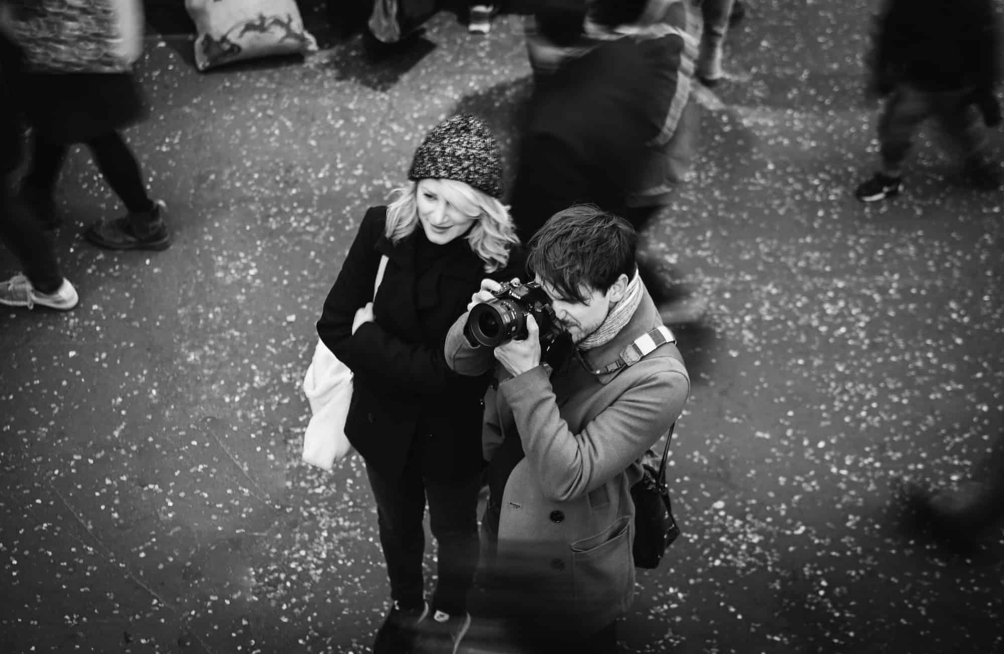 Send us your Paris stories and photos, like this couple in crowd, taking pictures.