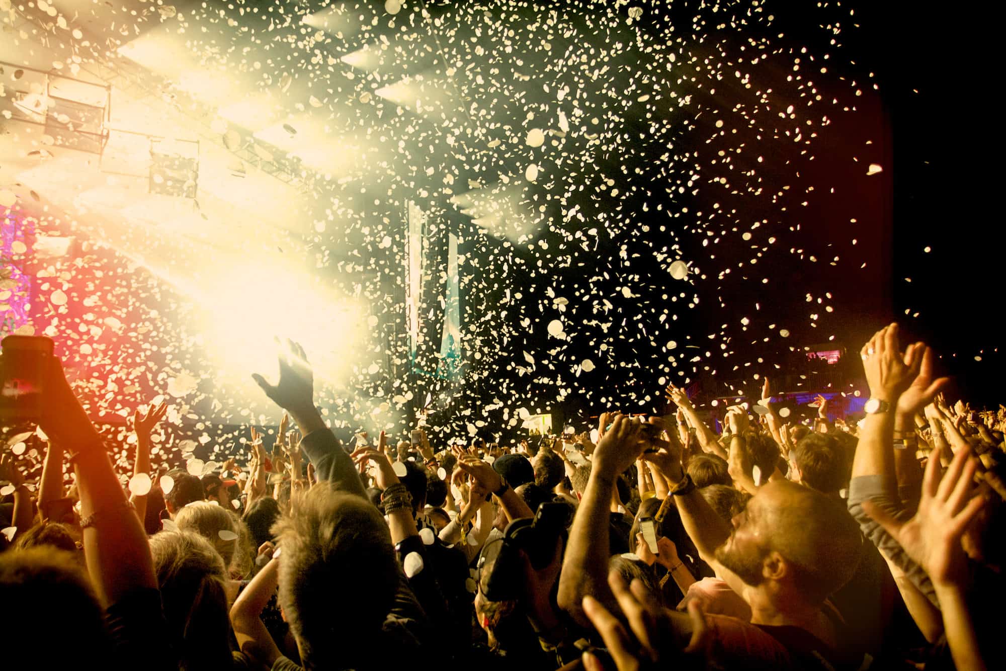 The crowds with their arms up at a Rock en Seine concert in August in Paris as confetti falls from the sky.