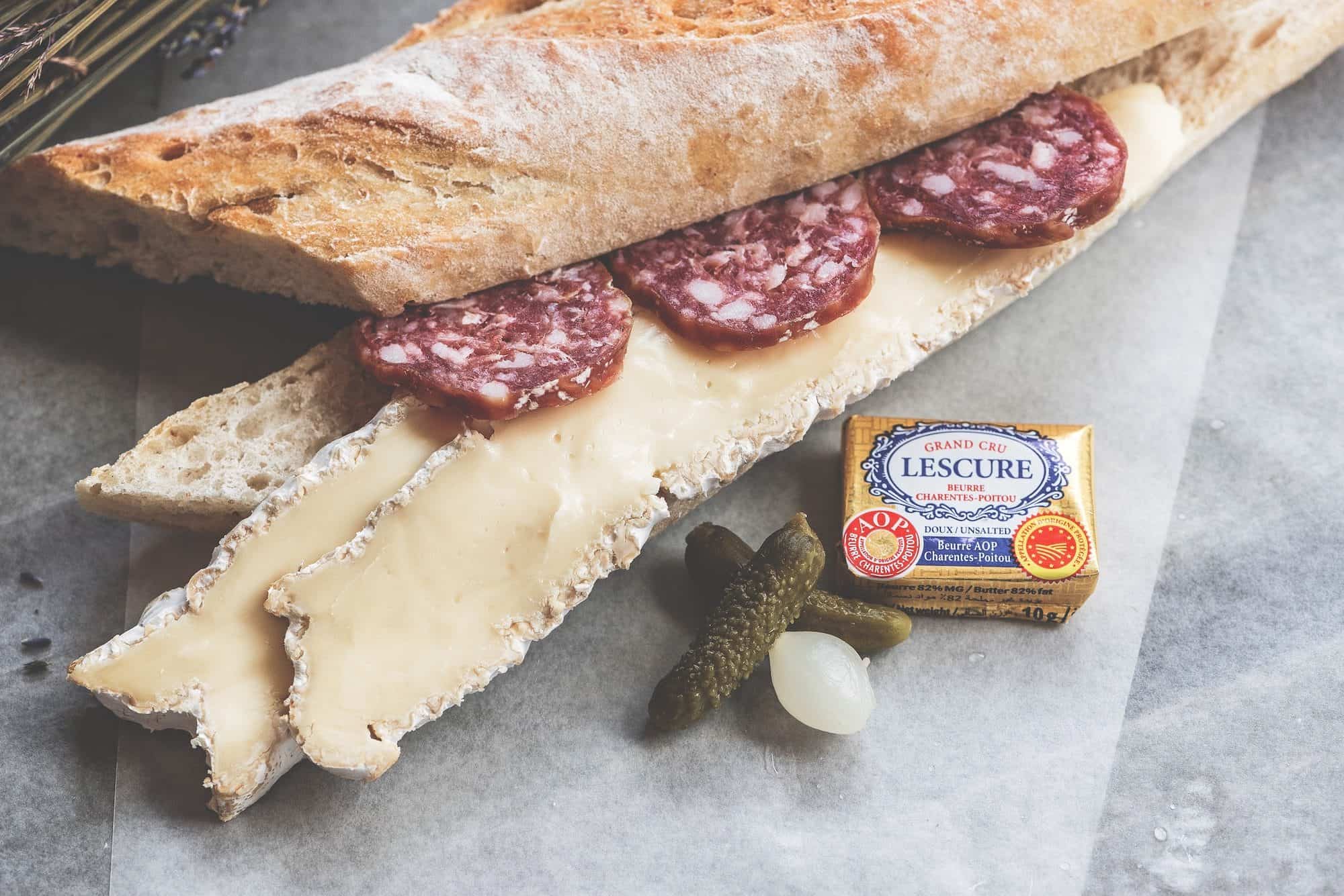 A delicious French saucisson and camembert baguette sandwich is perfect for a Paris summer picnic.