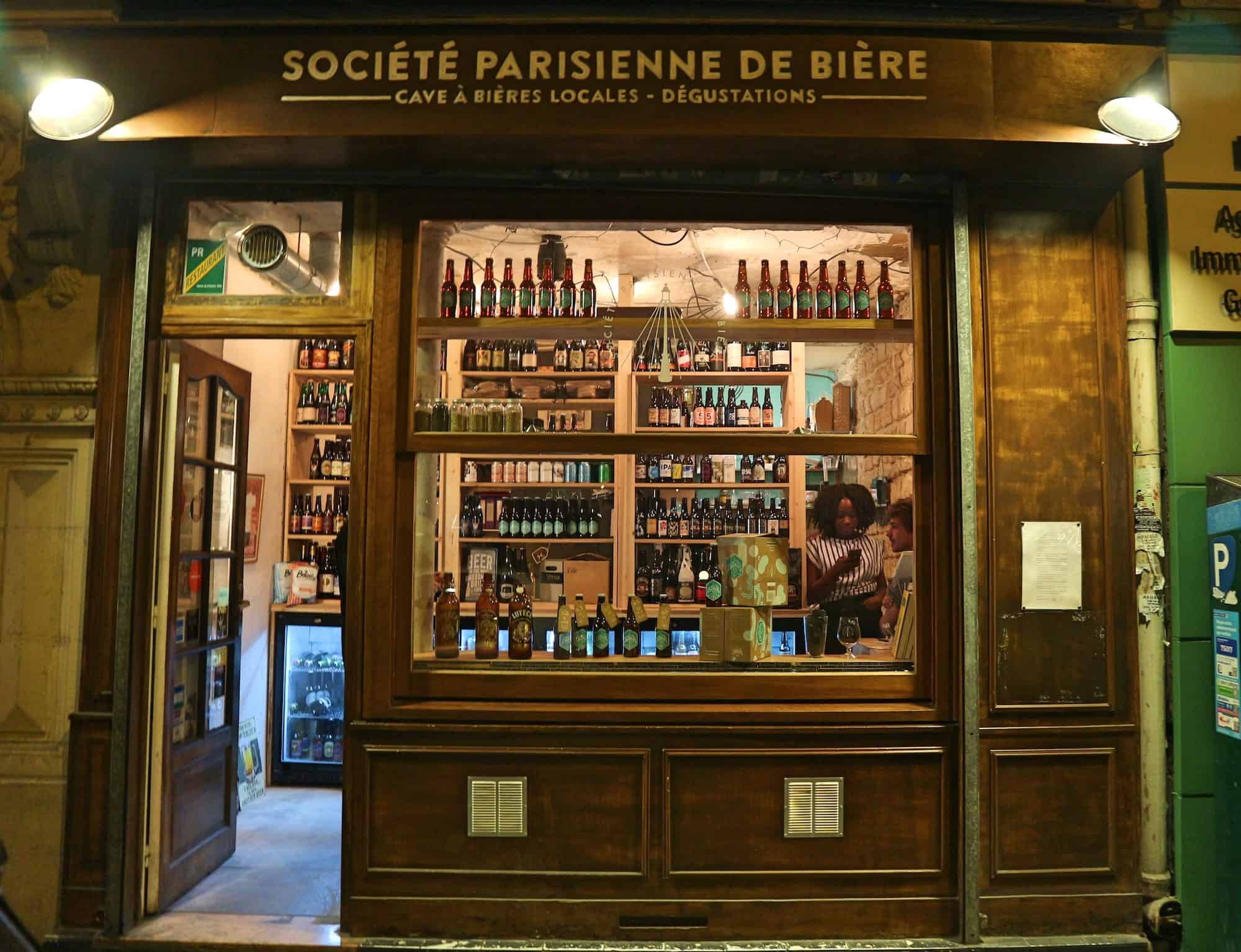 Craft beer shop in Paris, La Société Parisienne de Bière in the Batignolles neighborhood with its artisanal wooden facade.