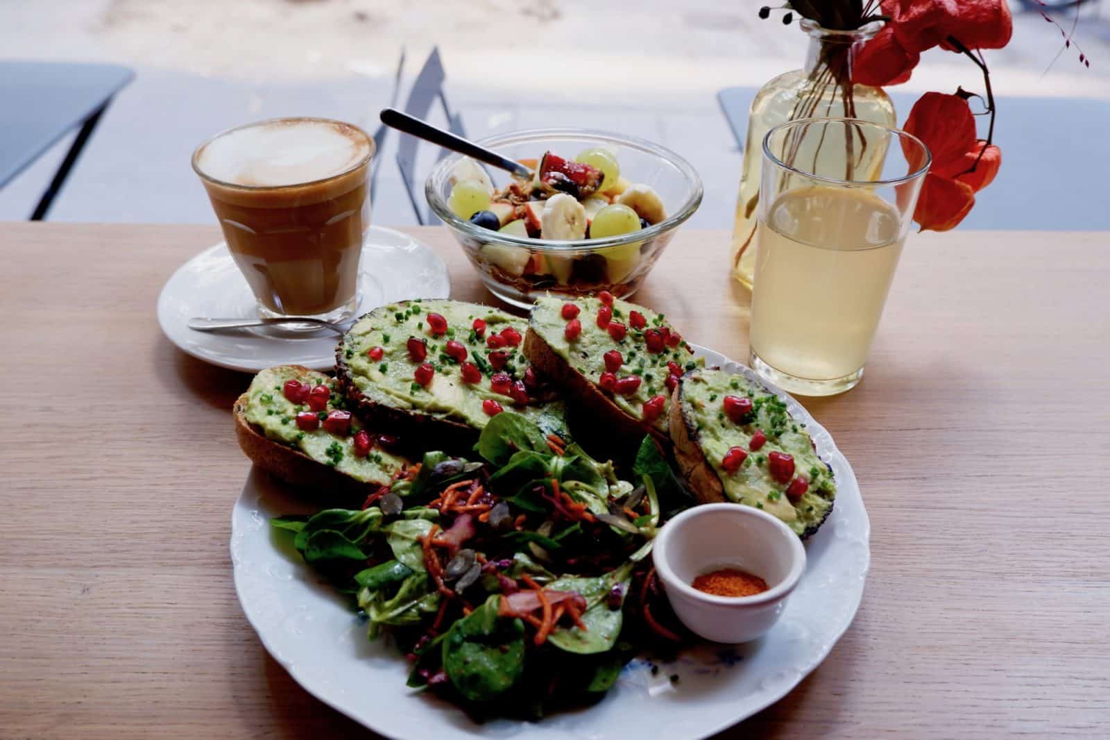 Creamy coffee, fresh fruit salad and avocado toast brunch at Mignon coffee shop in Paris 