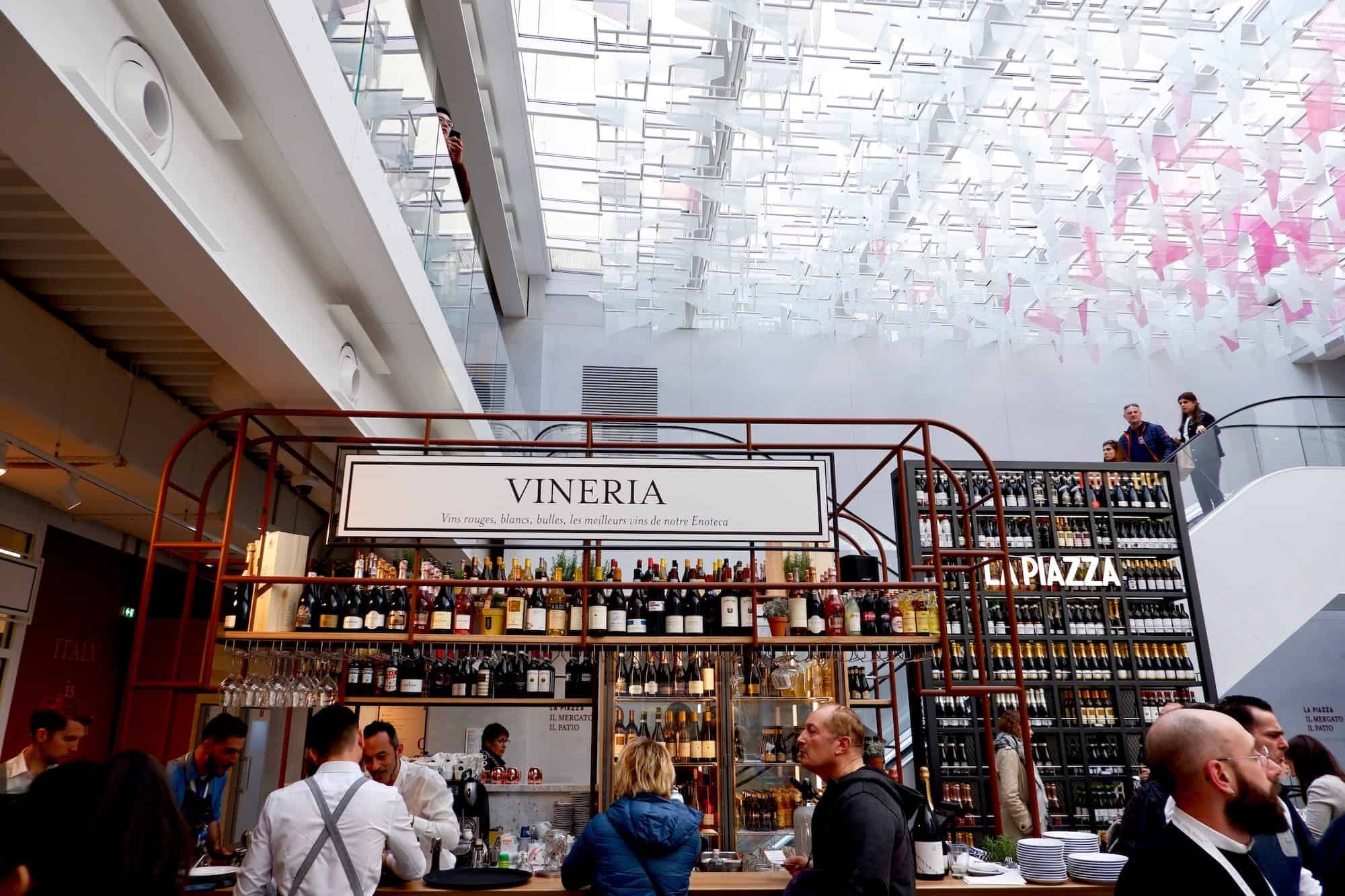The wine bar at Eataly, the place to go for Italian food in Paris sits under a glass roof, through which the light filters through, even on a dull day.