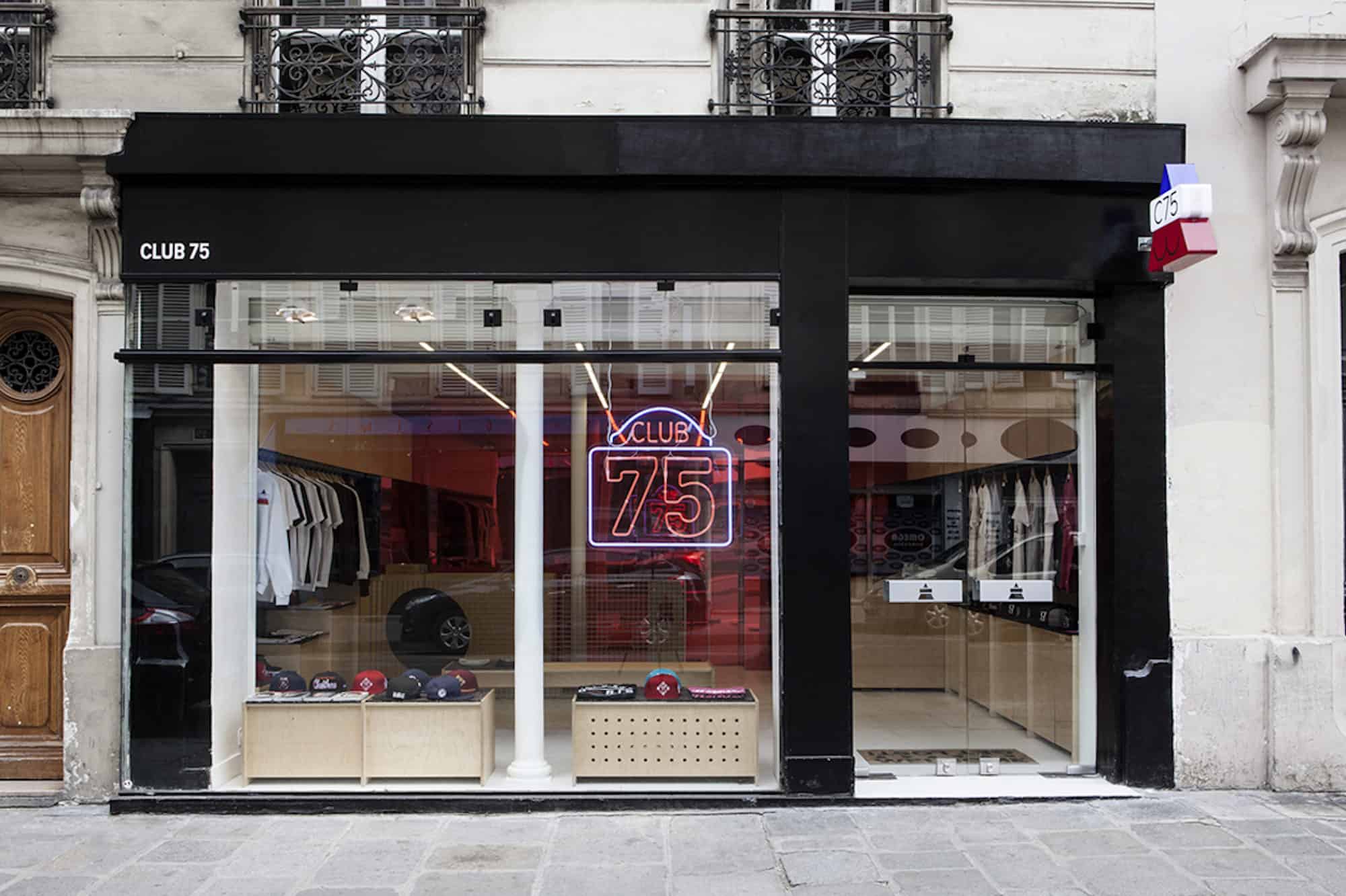 The window of Club 75 with a neon sign of the name of the store in Paris.