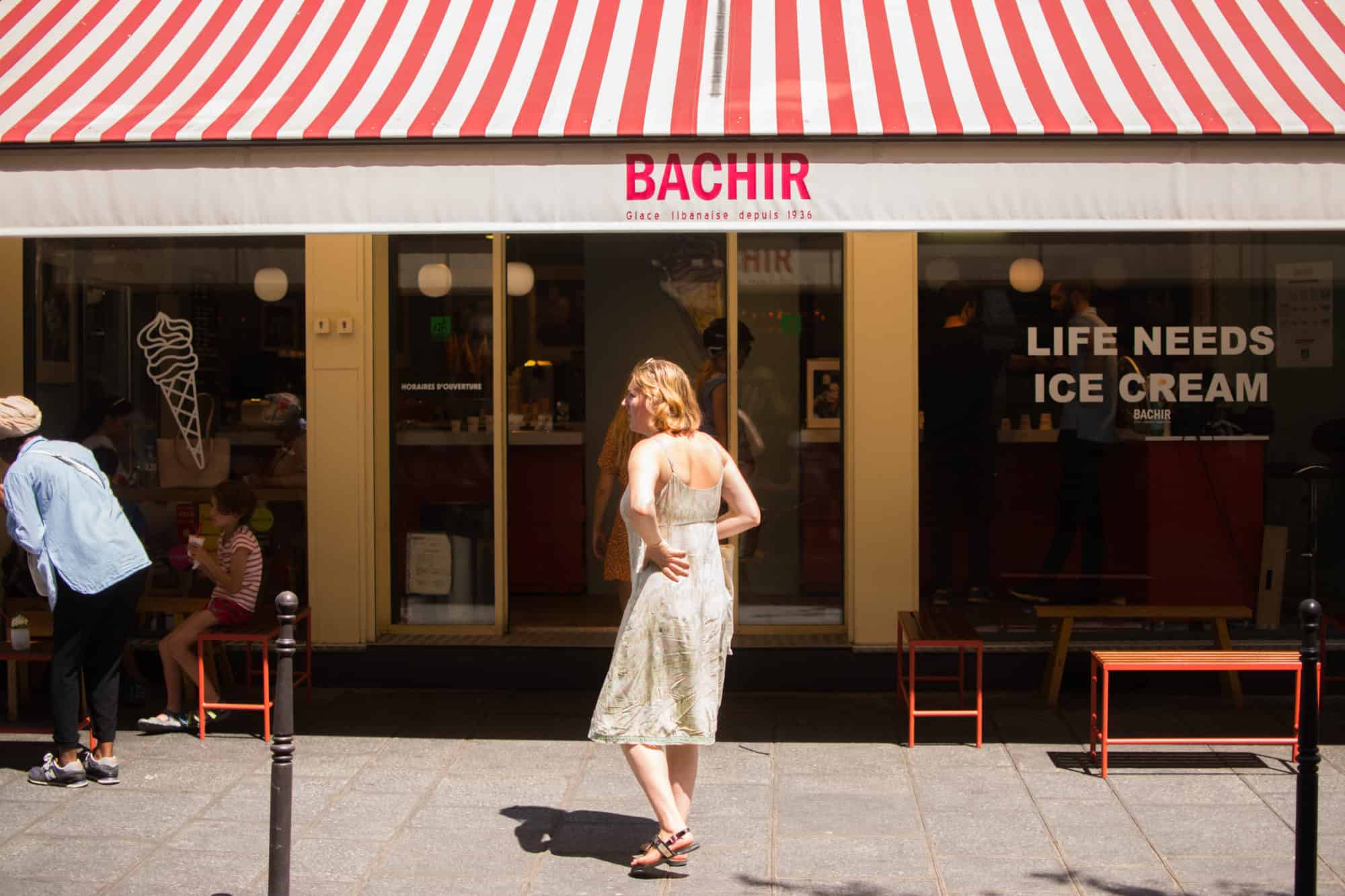 The exterior of Bachir ice cream shop in Paris with its stripy red and white awning. 