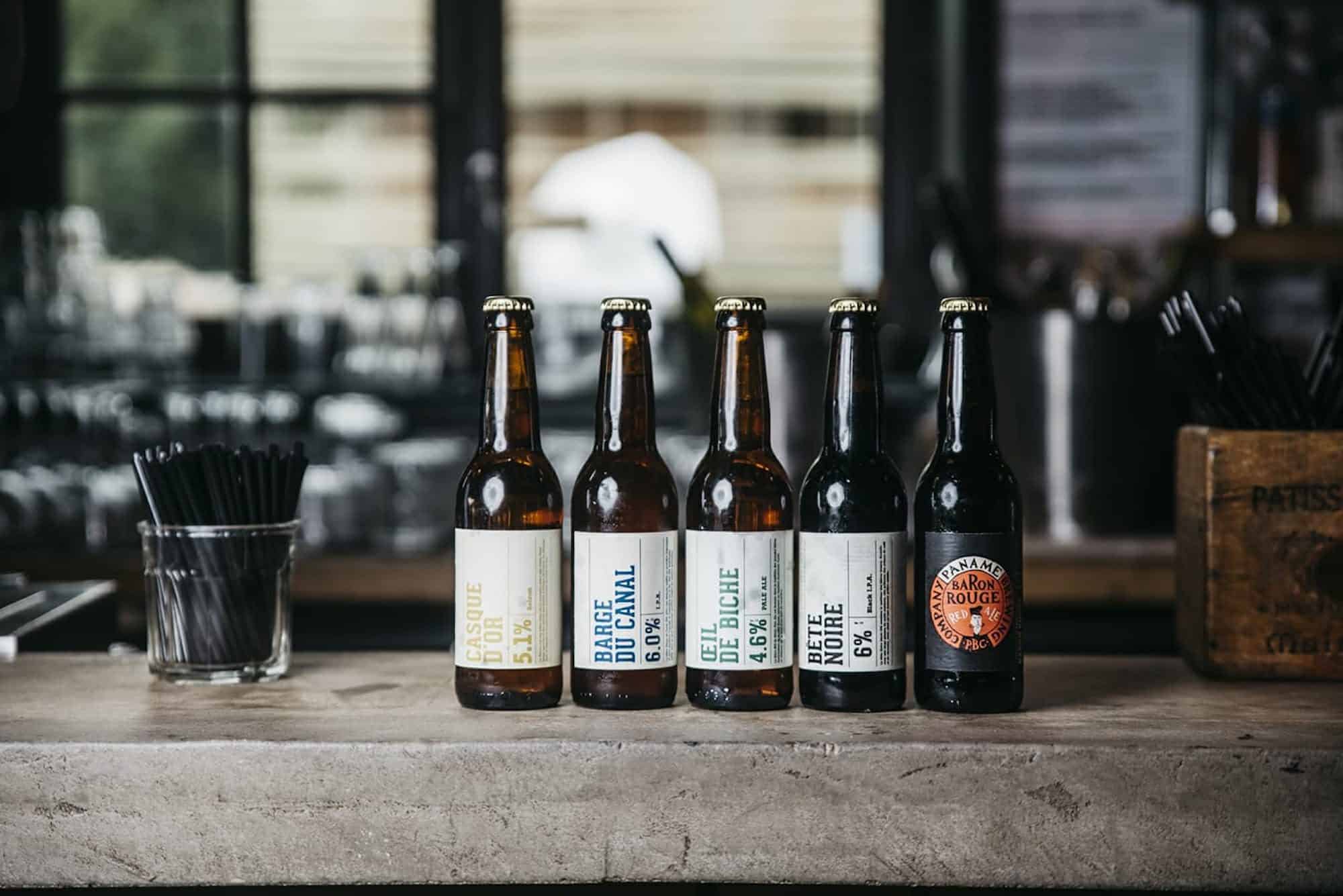 Five artisanal beers lined up on a bar counter