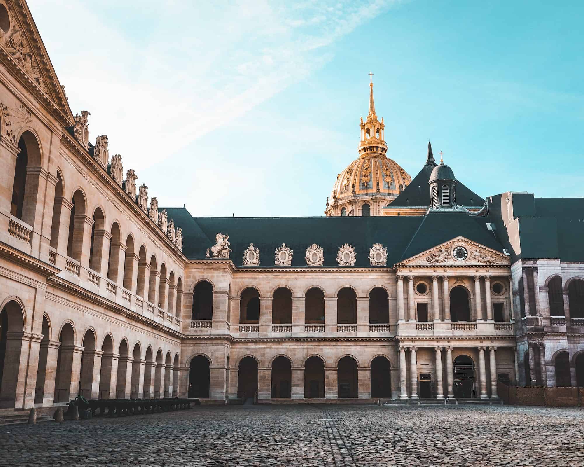 The interior cobblestone courtyard at the Invalides, with the gold dome sticking out the top.