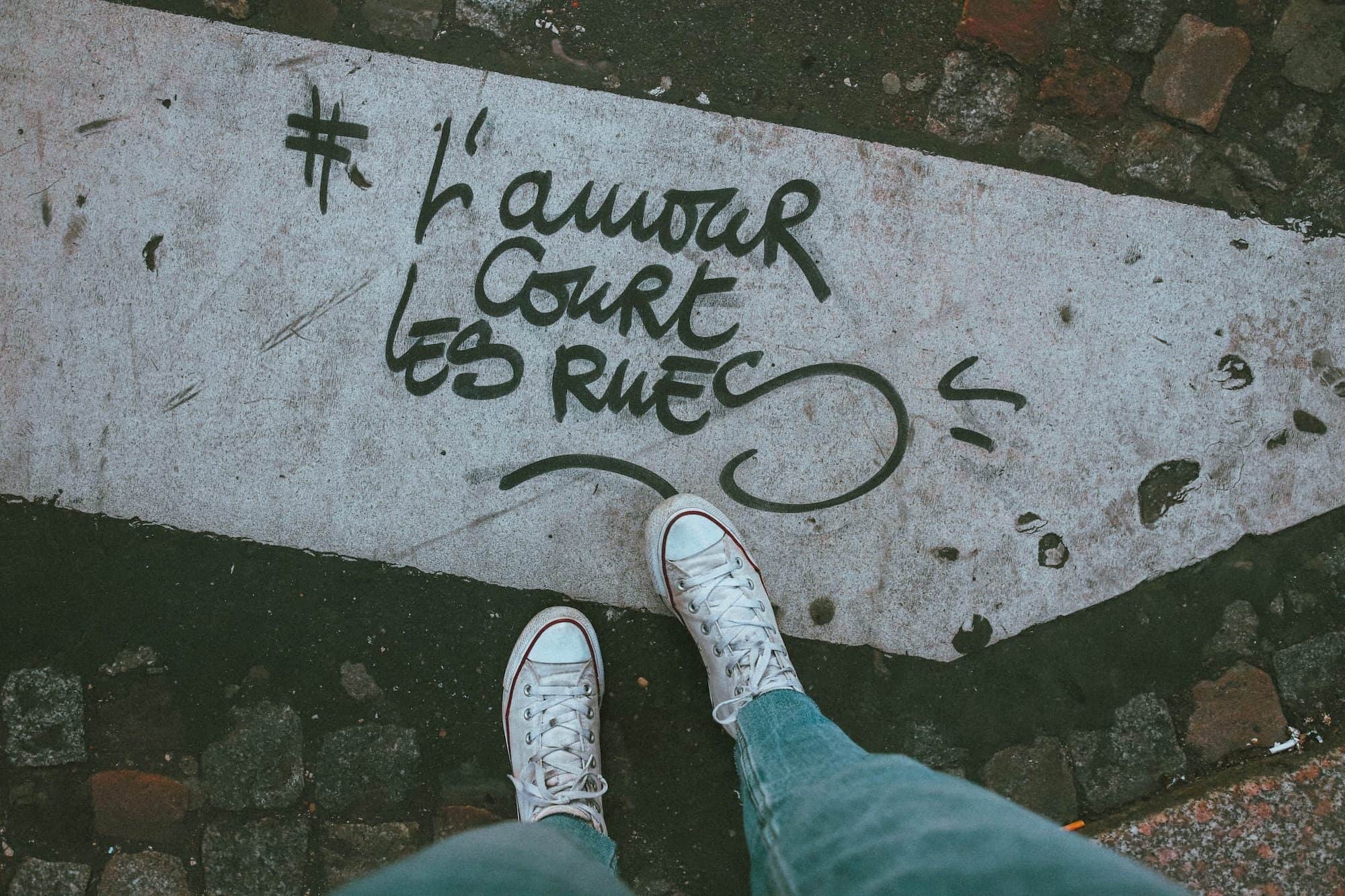 'L'Amour court les rues' (love flows through the streets) inscribed on a zebra crossing, which is a slogan that can now be found all over the city. 
