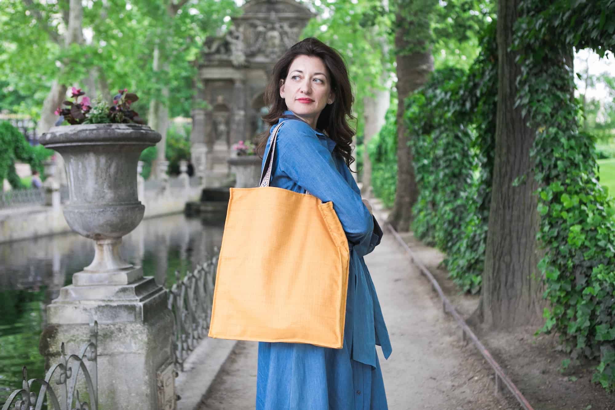 Kasia Dietz, founder of her eponymous handbag line, enjoys a lush spring day at the Medici Fountain in the Jardin du Luxembourg, one of her creamy orange tote bags slung over her shoulder.