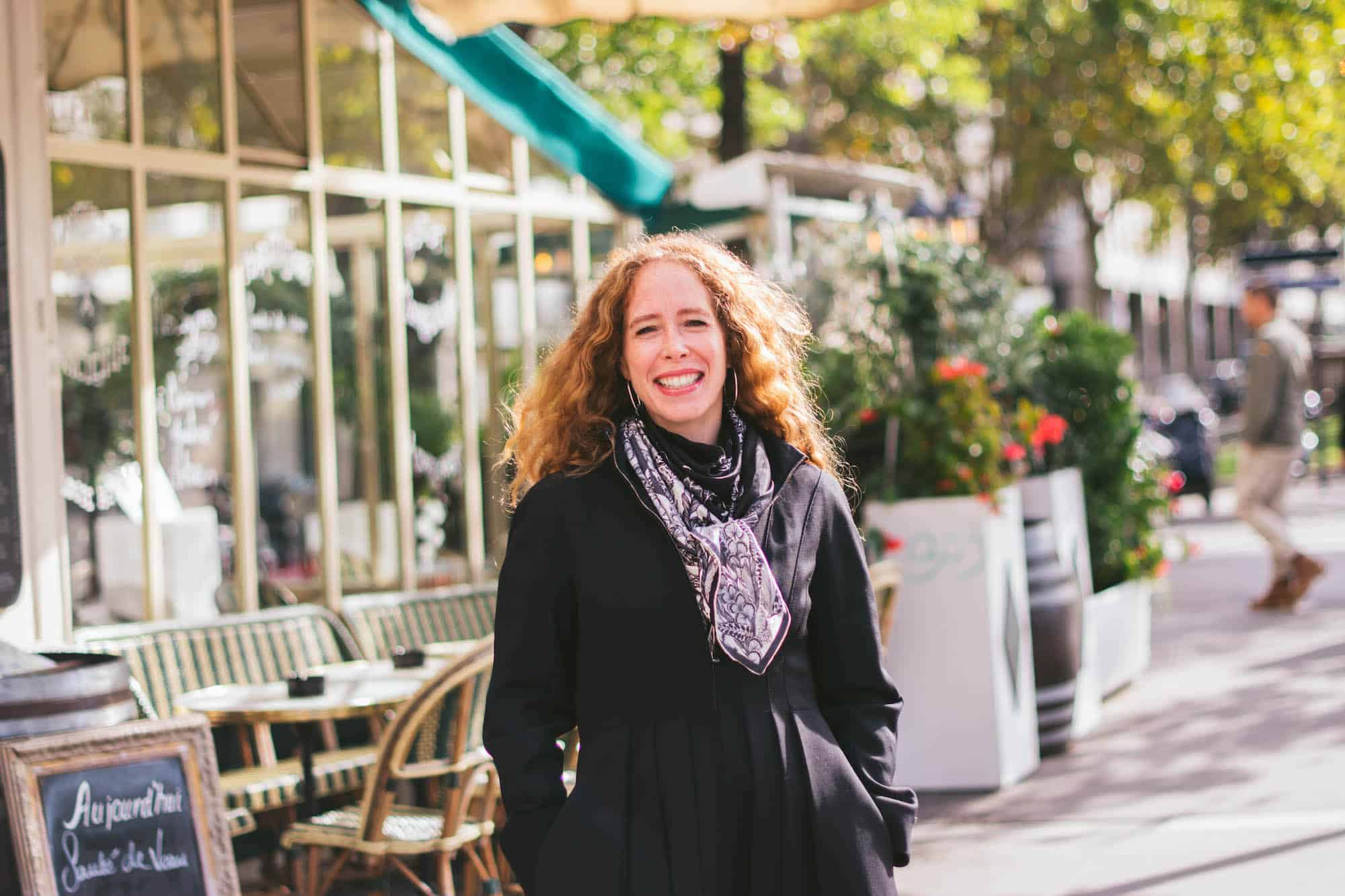 Jane Bertch, founder of La Cuisine Paris, smiles on a sunny fall morning, standing in front of one of her favorite Paris restaurants. 