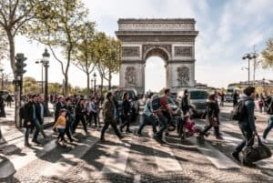 A large crowd of commuters walking in front of the Arc de Triomphe in Paris