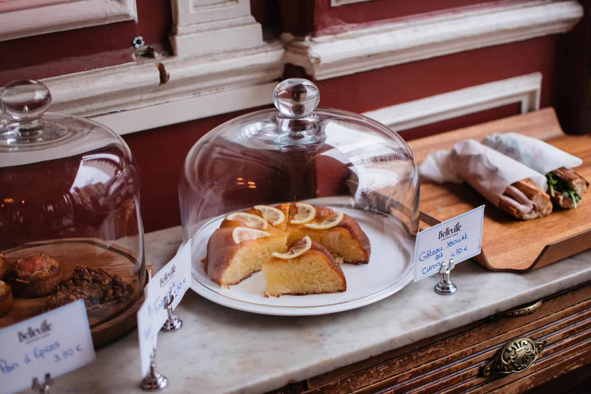 A selection of freshly bakes cakes and baguette sandwiches at a coffeeshop in Paris.