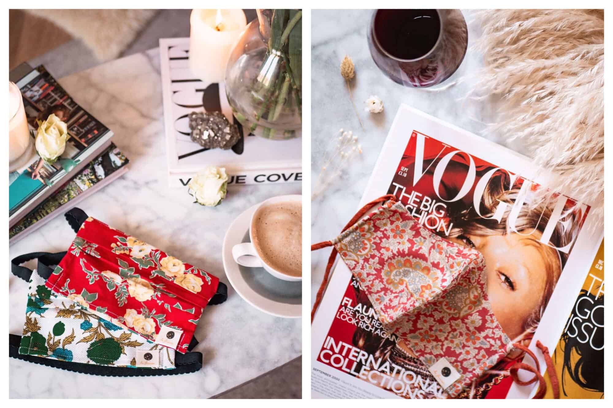 Left: a white blue and green floral face mask and a red and yellow floral face mask on a marble table next to a coffee, some magazines, candles and flowers. 
Right: a red and orange and beige floral face mask on a marble table with a Vogue magazine, dried flowers and a black tea.