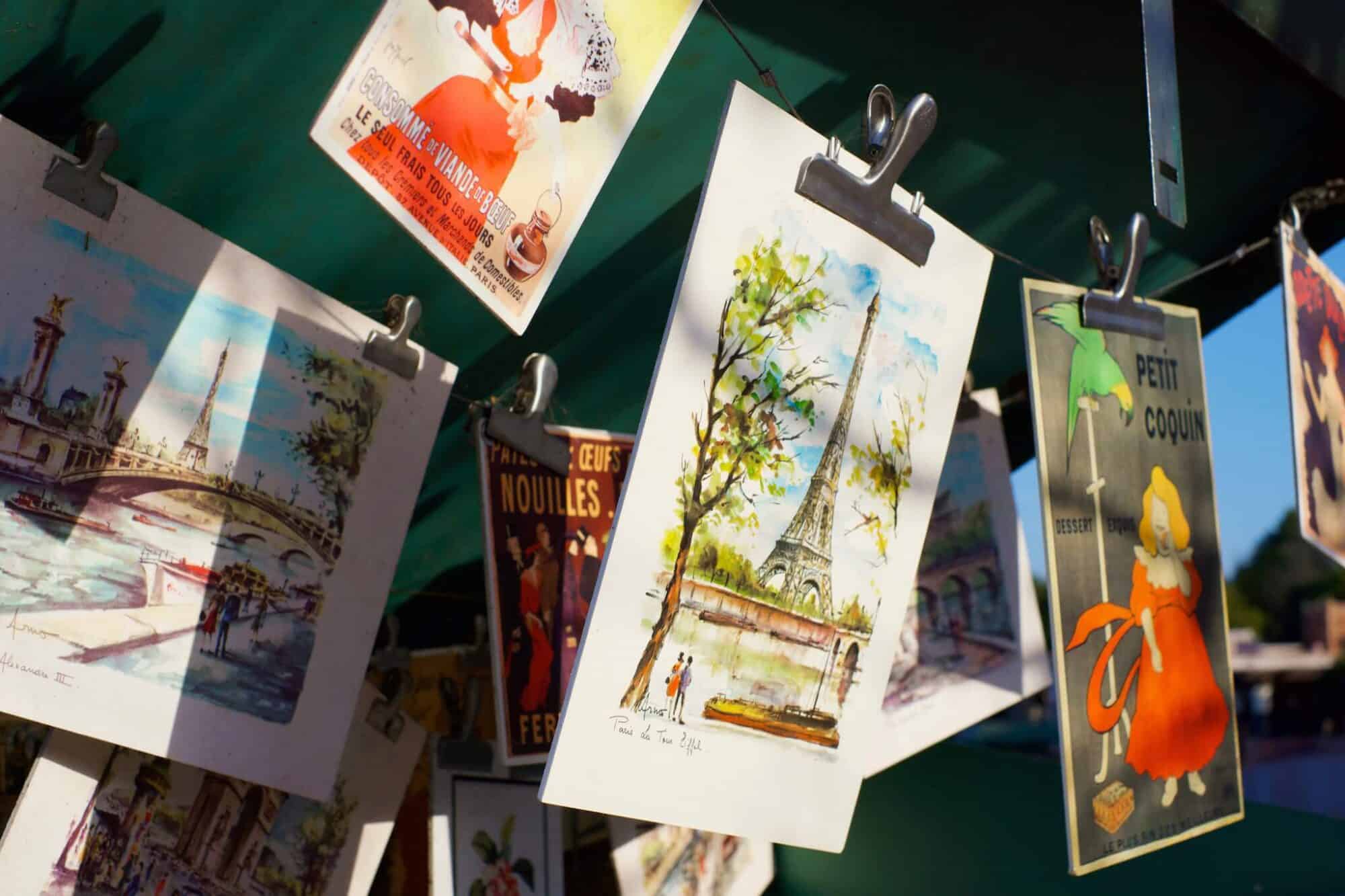 Beautiful hand-painted street art hangs from a vendor's booth along the Seine in Paris.