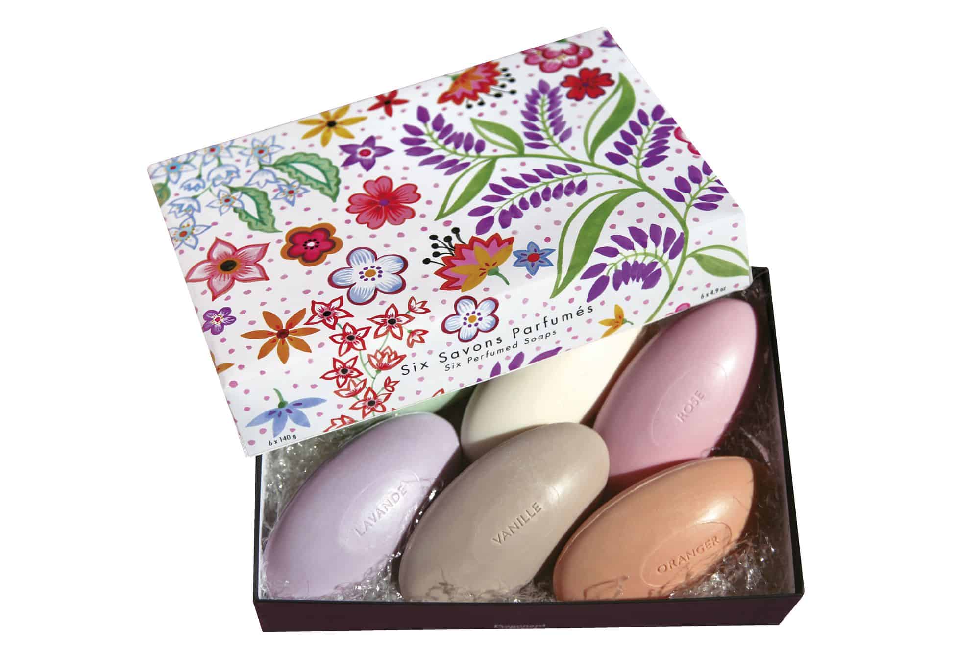 A beautiful box with flowers printed on the lid is open to show colorful-- purple, yellow, brown, pink and orange-- Fragonard soaps.