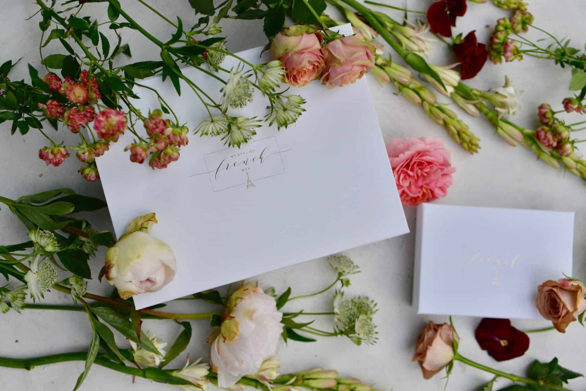 A handwritten invitation lying amidst flowers.