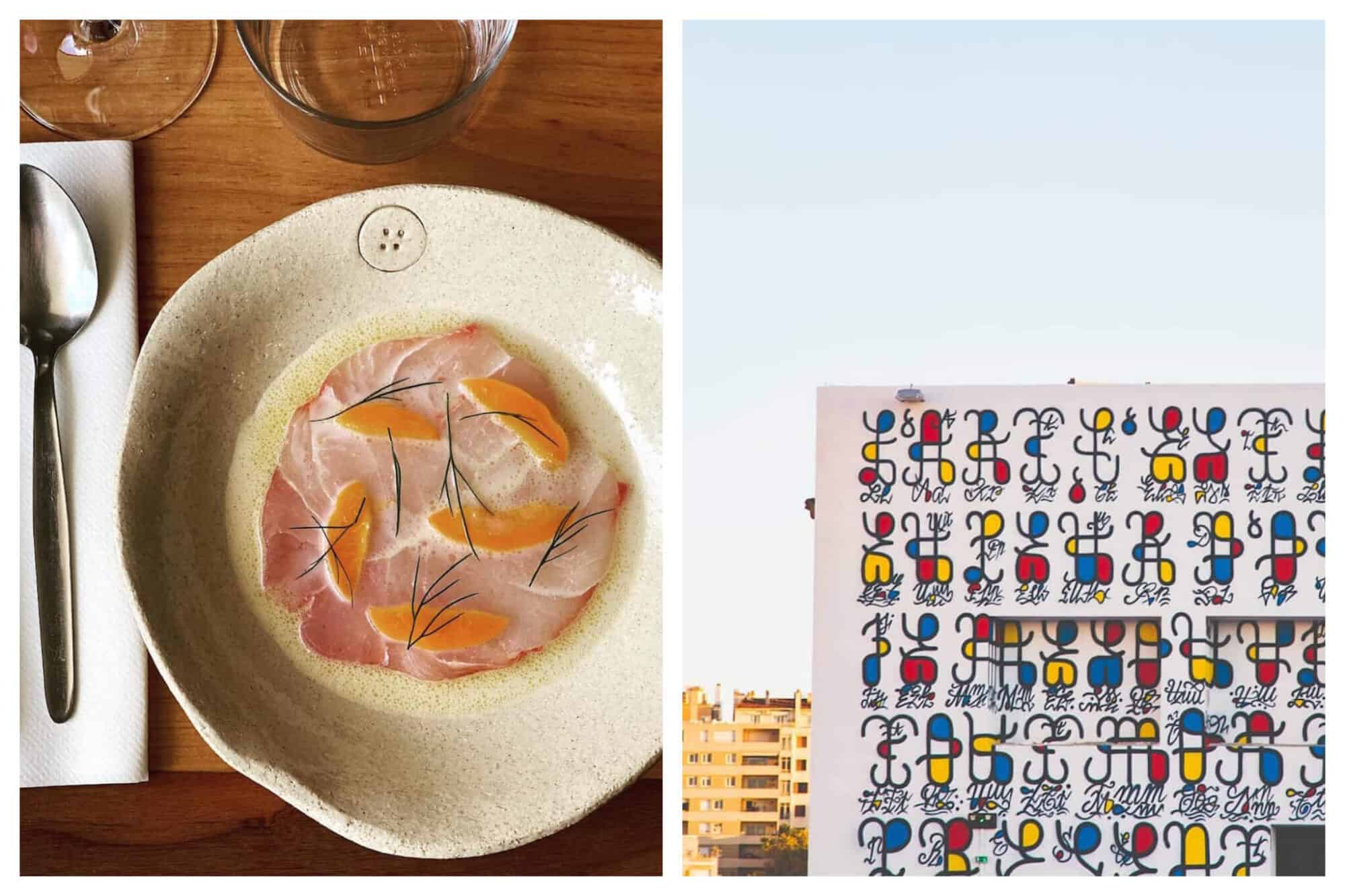 A fancy plated dish of gastronomy at La Mercerie: some sort of fish tarter with orange segments sat atop and sprigs of herbs. On the right is a colourful mural  of abstract figures which seem to represent persons and how they interact in the community.