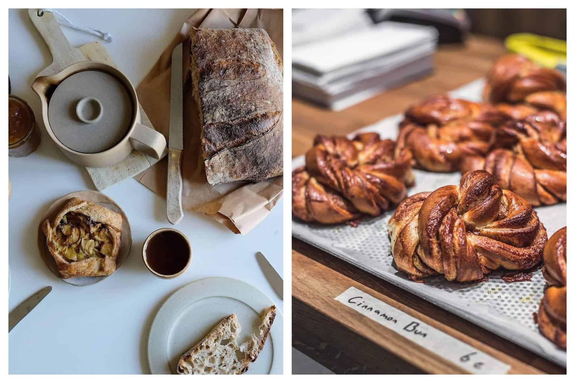 Left: a table with a tea kettle sitting on a cutting board, a cup with tea in it, a large loaf of bread with a knife next to it, a small plate with a slice of bread on it, and an apple tart. Right: A display with several cinnamon buns with a small piece of tape with "cinnamon buns 6€" written on it.   