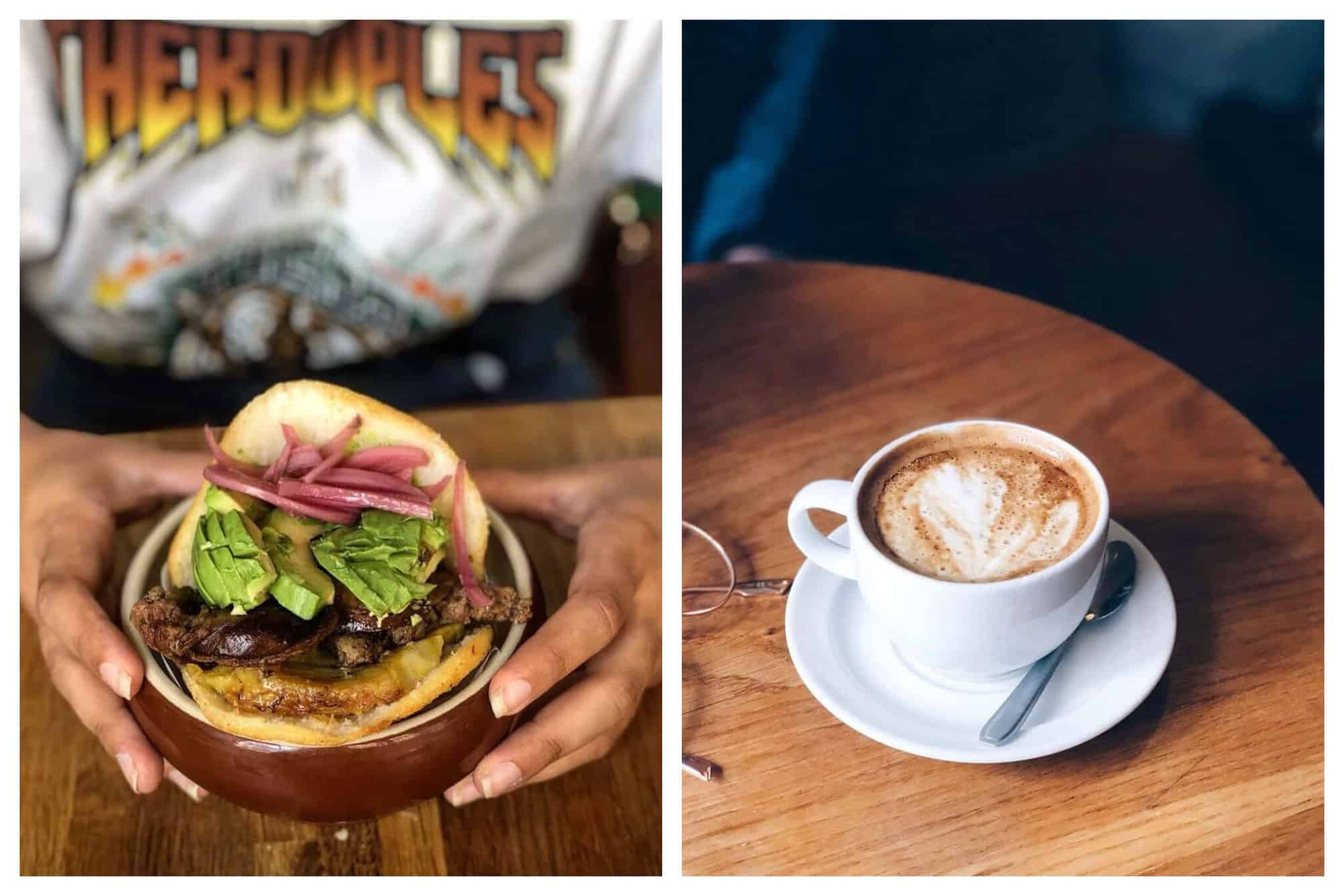 Left: a woman's hands holding a sandwich from Bululu Arepera. There is meat, avocado, and red onion in the sandwich and it is in a traditional Venezuelan bun. Right: a cup of coffee with foamy milk on a table. The cup is white and it is on a white saucer with a small spoon.