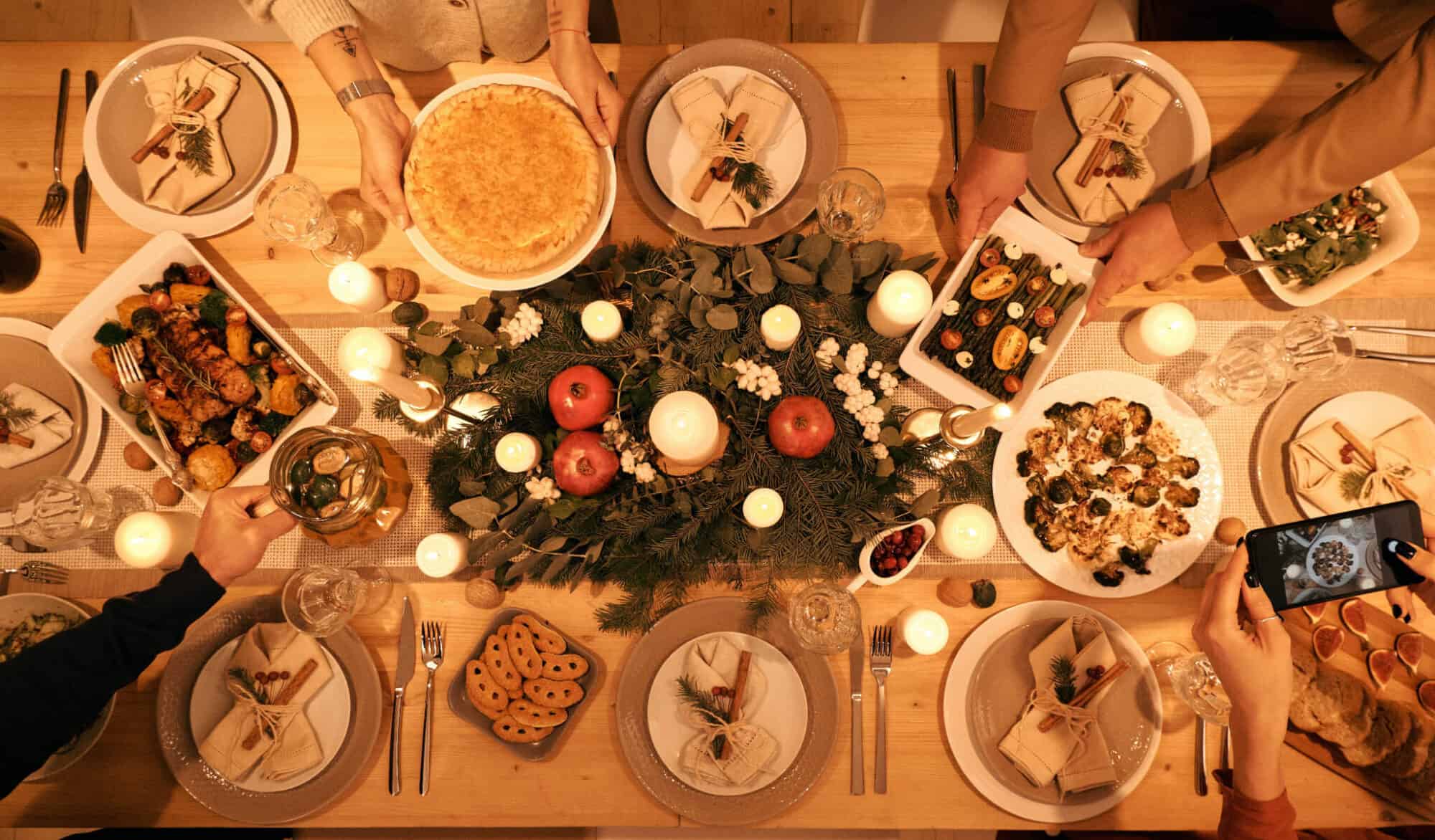 A dinner table for the holidays full of delicious dishes and winter decoration.
