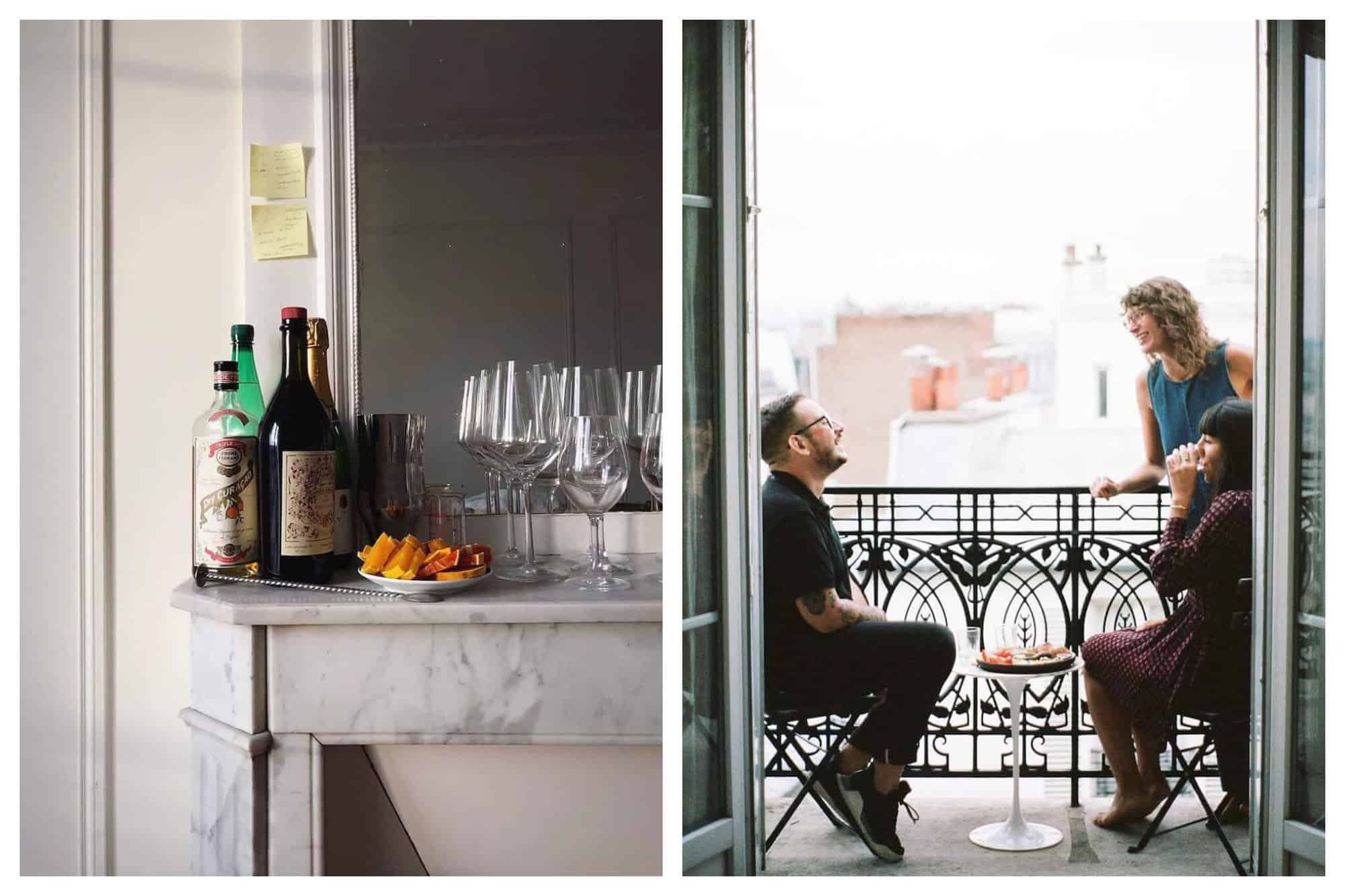 Left: a Parisian fireplace mantle with bottles of alcohol, citrus fruits, and several glasses. There is a mirror on the mantle. Right: A group of three people on a Parisian balcony. There is a table with plates of food and glasses and there is a man sitting on a chair to the left, there is one woman standing to the right, and another woman sitting in a chair and drinking.