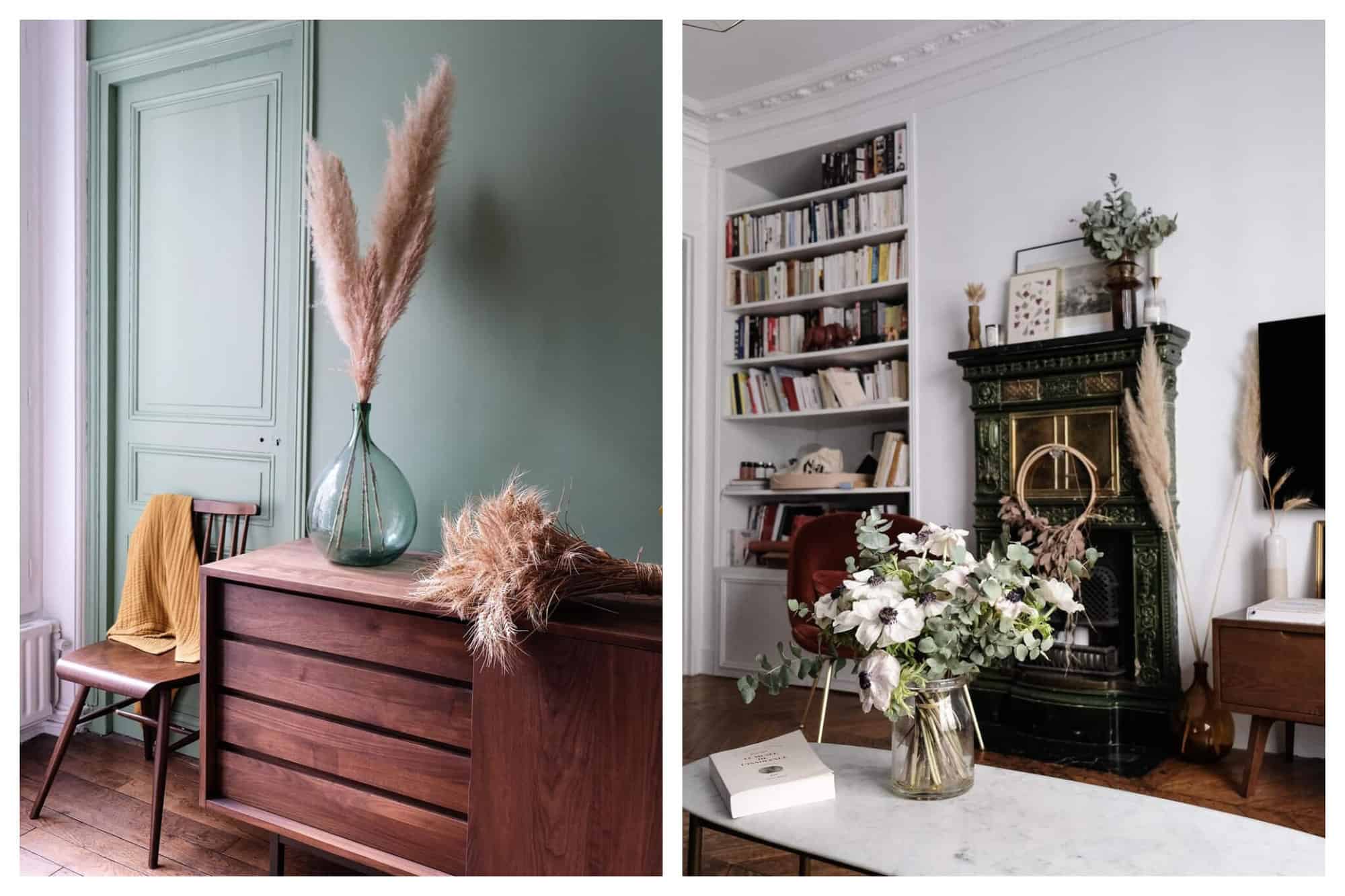 Left: A teal room is pictured with a dark wooden chair and dresser. On top of the dresser there is a large teal vase with dried pink flowers, and some dried wheat next to it. Right: A well decorated white room including a large bookshelf built into the wall and filled with books, a white marble table with a vase of dried flowers and a small, dark vintage fireplace.   