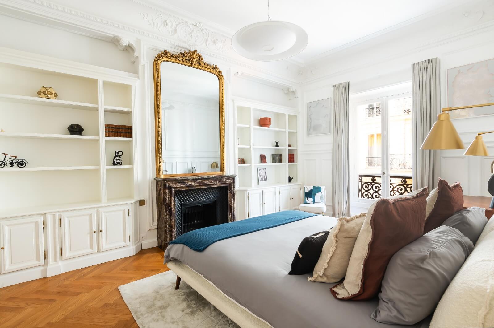 a huge gold mirror over a fireplace in a Paris apartment.
