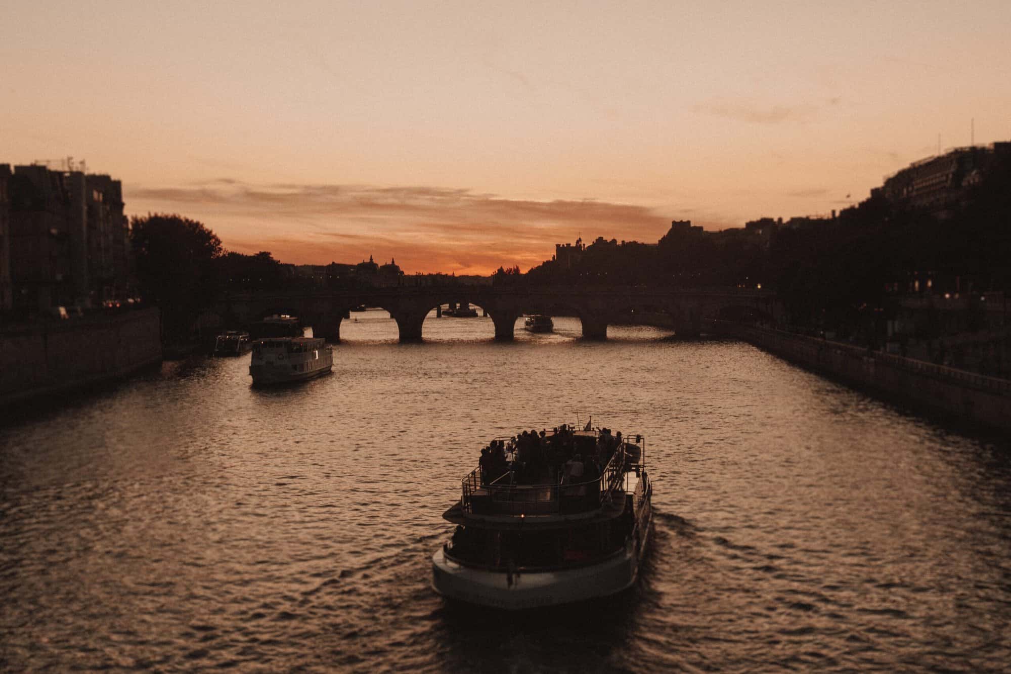 Boats on the Seine in Paris by sunset.