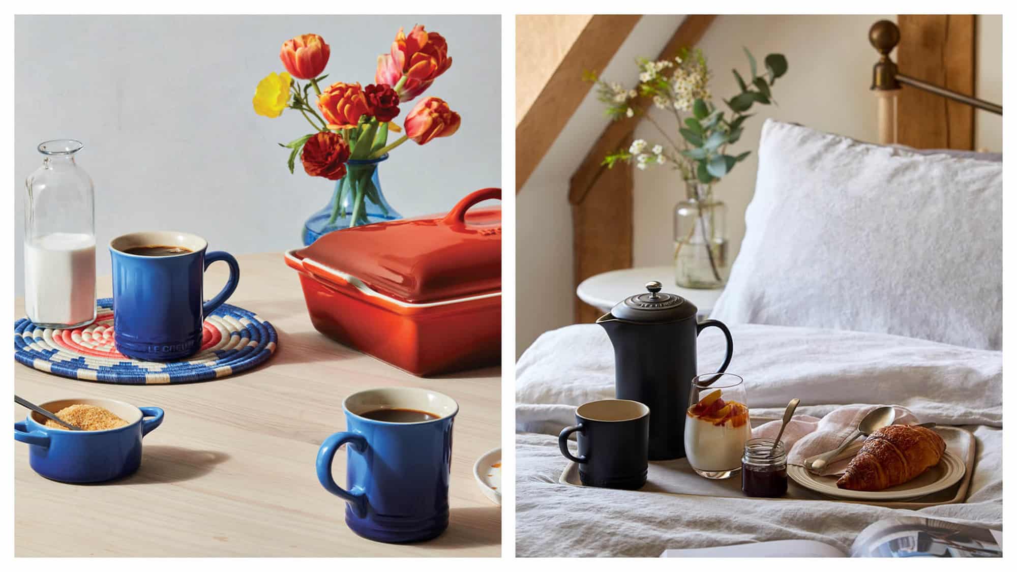 Left: two blue mugs, a sugar bowl, and a red casserole dish by Le Creuset sitting on a table with a glass bottle of milk and a vase of flowers. Right: a black ceramic French press and mug by Le Creuset sitting on a breakfast tray with a croissant, jam and yoghurt on a bed. 