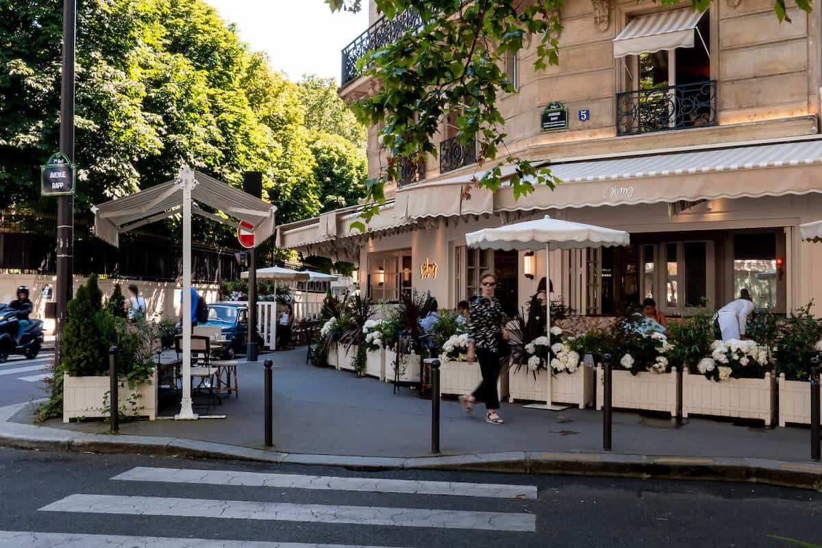 The sidewalk terrace of L'Alma café on a sunny day in Paris.