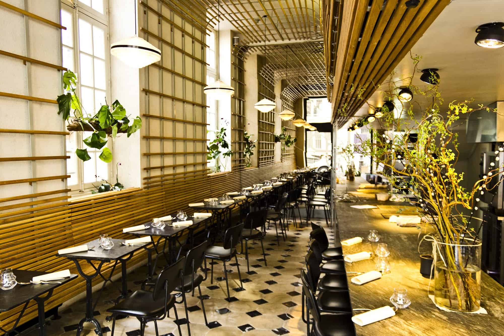 Left: the interior of the restaurant Dessance with wood panelling, plants, tiled floor and black tables and chairs.