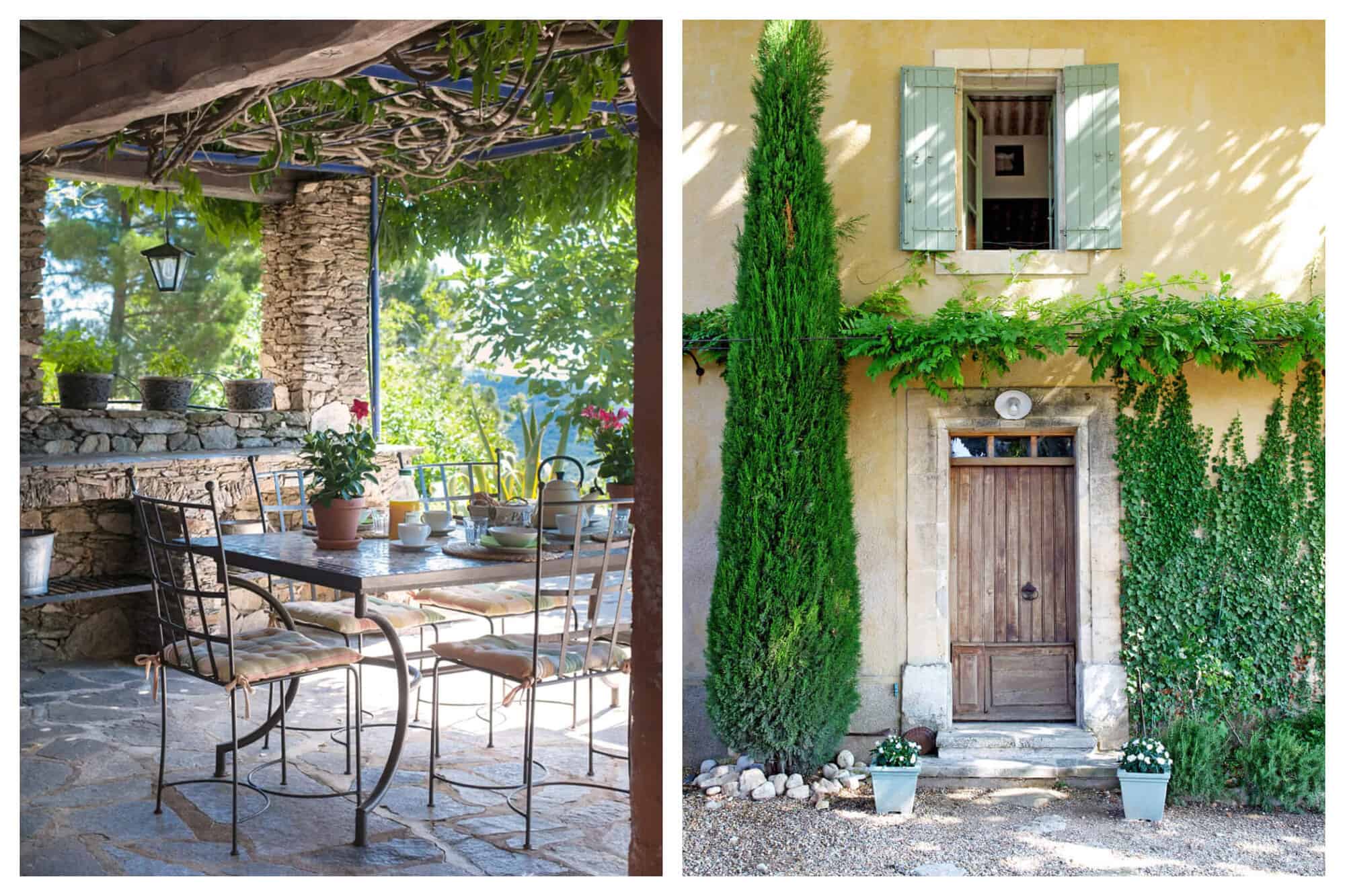 A table set for lunch on the terrace at St. Saturnin with stone floors and walls. An old door and window of the Bonnieux villa with colourful plants and a cypress tree.