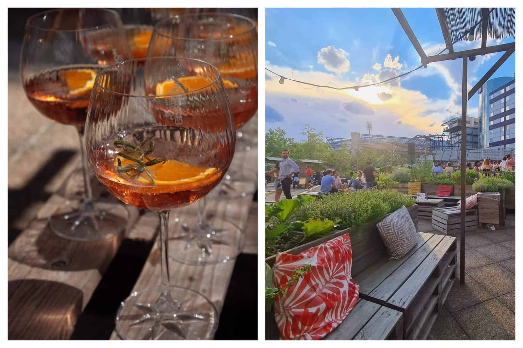 Three wine glasses with Pimms served with orange and rosemary. Light breaks through on a cloudy day at the busy terrace of Le Papa Cabane.