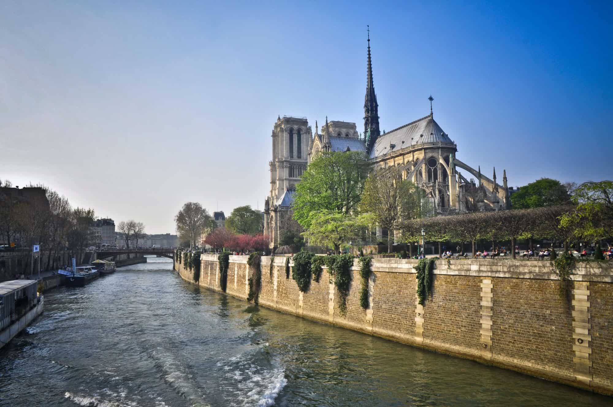 Notre-Dame is sat next to the Seine on a sunny day