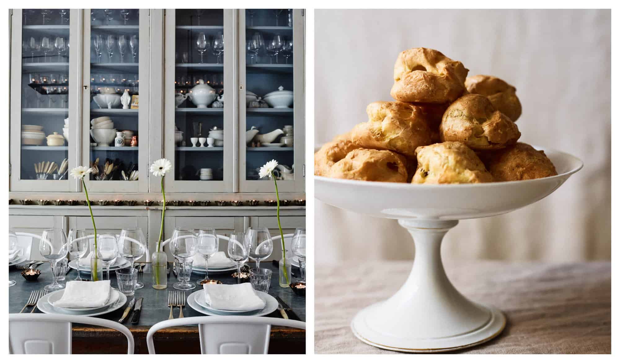 Left: A dining table laden with wine glasses, white plates, and white flowers, is pictured in front of a sage cupboard filled with dishes. Right: A plate of Gougères presented on a white plate.