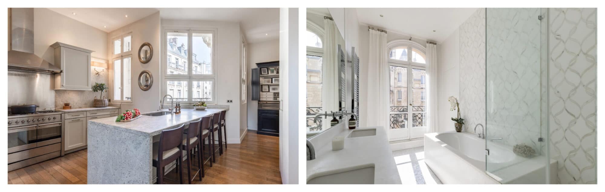 Left: a small kitchen in a Paris apartment with a stone island, wooden floors and 3 large windows overlooking classic Parisian buildings; Right: a newly remodeled bathroom with a white marble double sink, white bathtub, white and grey patterned wallpaper, and large window with white curtains looking onto the historic buildings of the Marais.