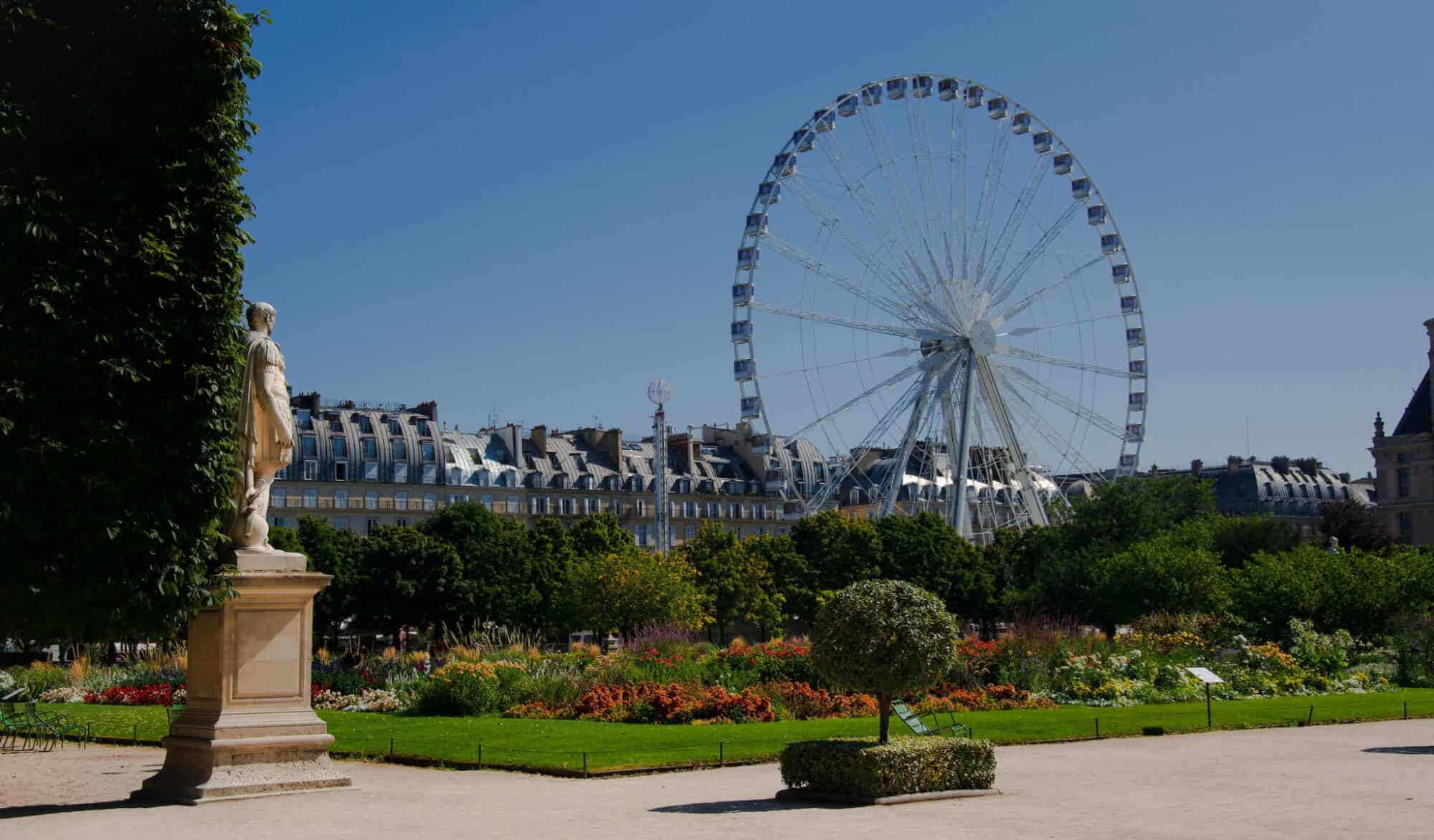 A huge ferris wheel in the middle of a park in Paris.