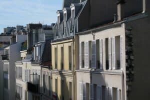 A line of Parisian buildings in yellow and white walls and their iconic zinc rooftops.
