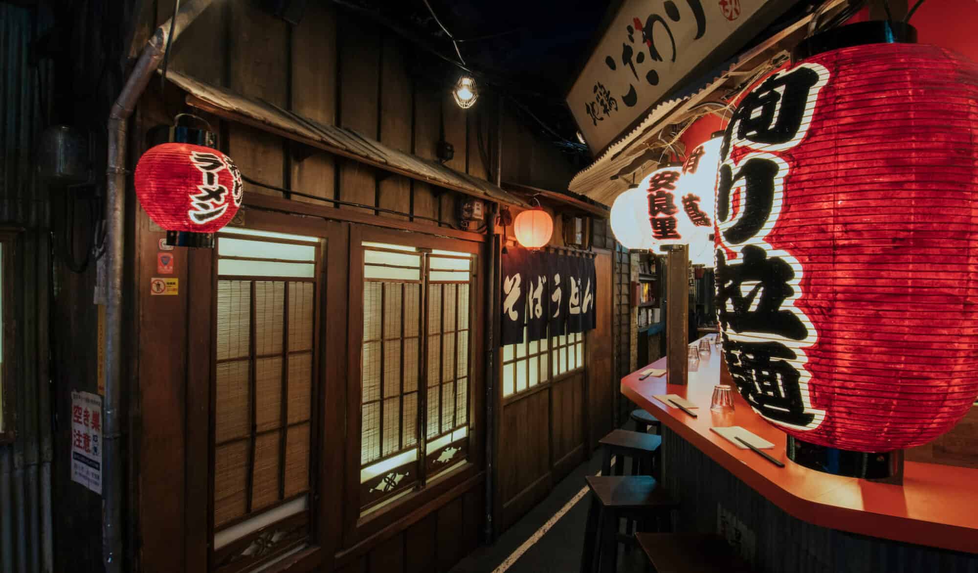 Inside Kodawari Ramen's Japanese market-inspired noodle bar, with Japanese paper windows and red lanterns.