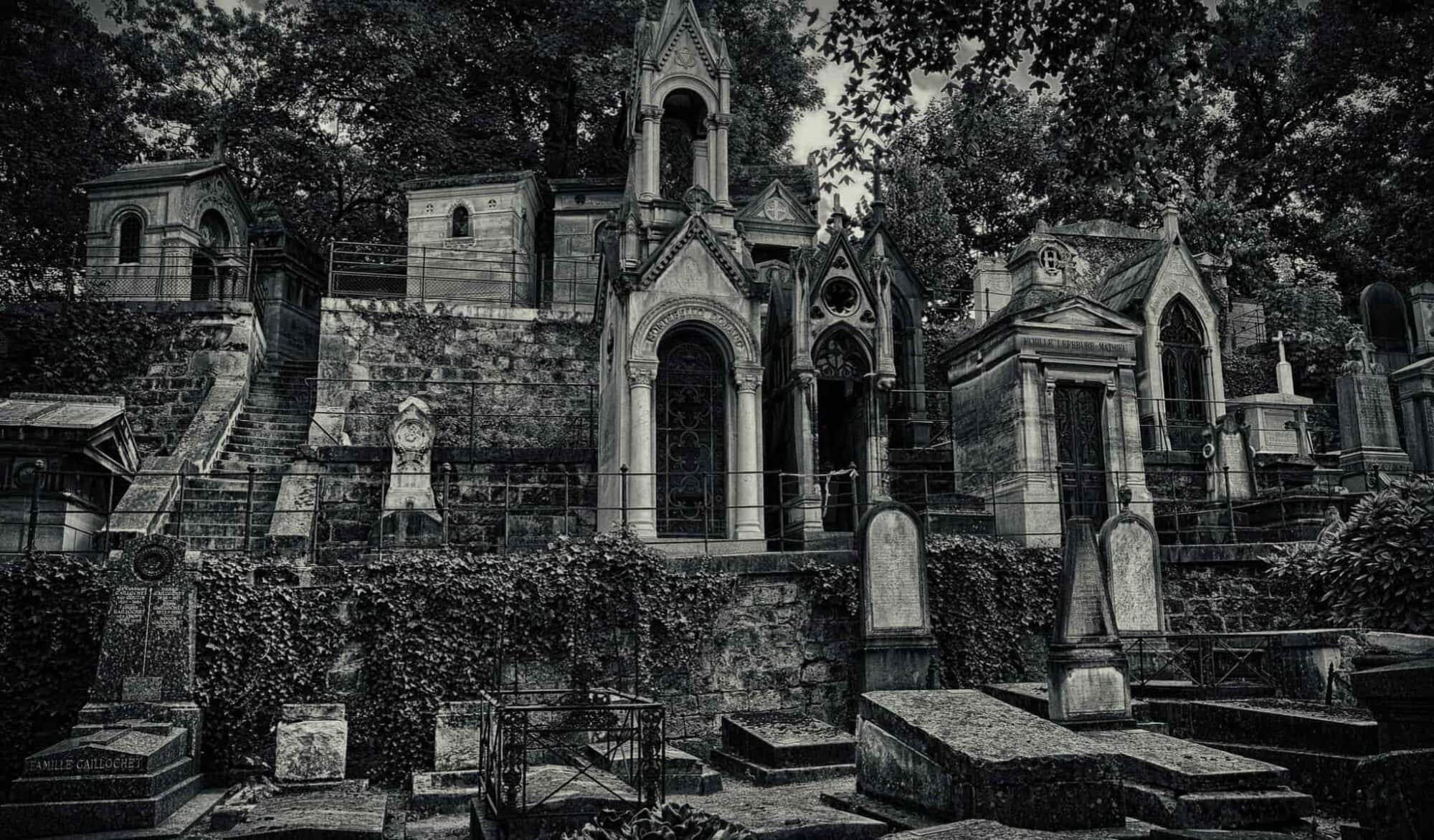 The stone gravestones crowded next to each other in Montparnasse Cemetery photographed in black and white.