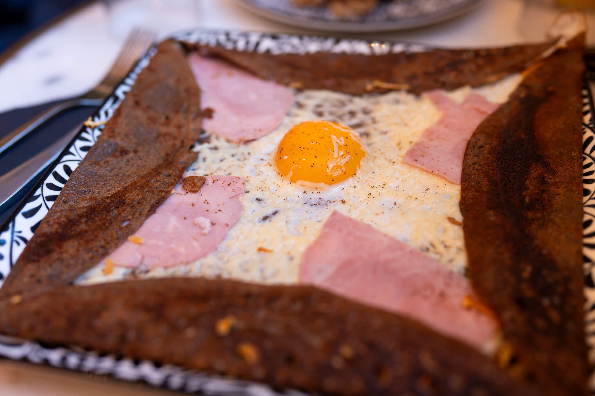 A ham a cheese crepe with egg on top. 