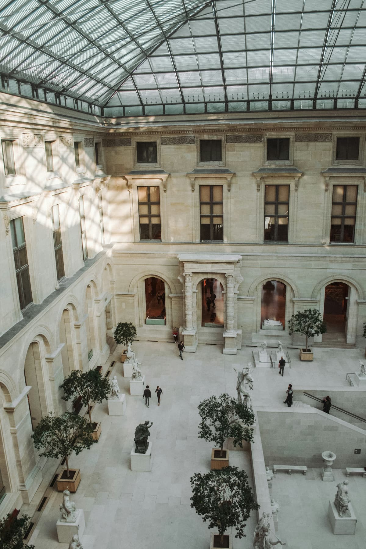 A courtyard inside the Louvre with a view of the glass roof