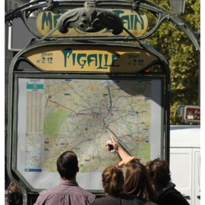 Tourists in Paris looking at the map in front of Pigalle metro station