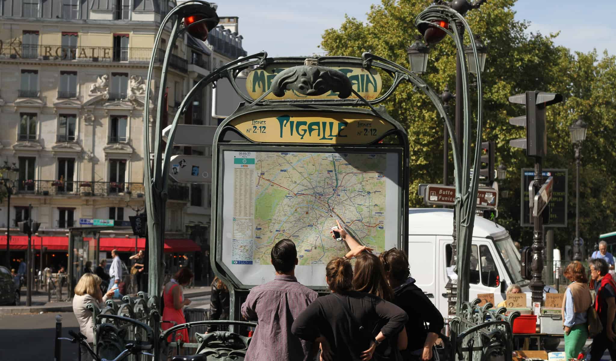 Tourists in Paris looking at the map in front of Pigalle metro station