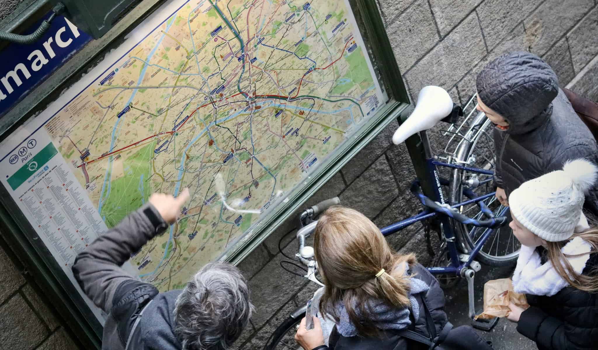 People looking at the map in front of a metro station in Paris